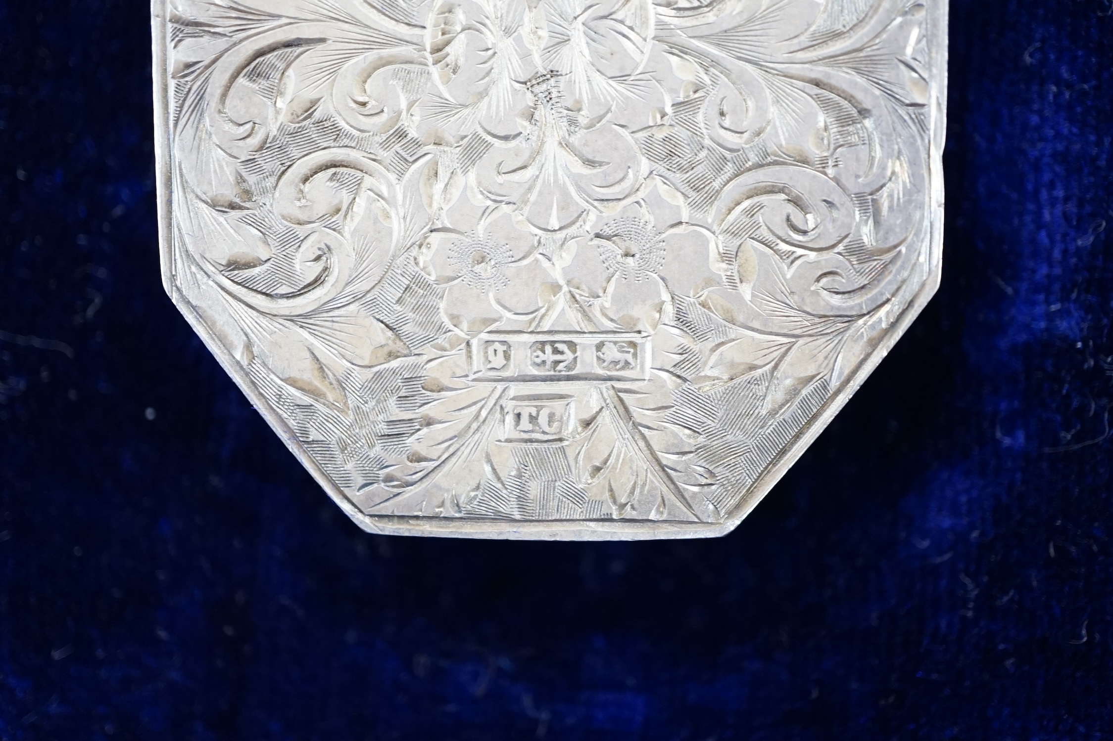 A Victorian silver octagonal locket with engraved aesthetic decoration, Birmingham, 1881, 43mm, on a white metal Etruscan revival chain, 42cm, in fitted case.